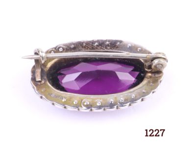 Edwardian silver petite oval brooch with amethyst coloured stone surrounded with seed pearls Photo showing back of brooch