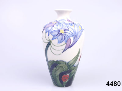 Signed Moorcroft vase by Rachel Bishop called "Fly Away Home". Decorated with blue flowers and ladybirds. No original box. Measures 40mm in diameter at base and 35mm in diameter across the top. Main photo showing one side of vase from an eye level angle