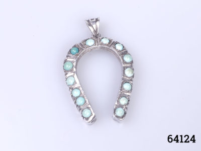 Vintage Egyptian silver horseshoe pendant. Lucky horseshoe encrusted with small turquoise bead stones all the way round. Drop length 45mm from bail Main photo of pendant on a flat surface with bail at the top and horseshoe ends at the bottom