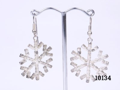 Vintage costume jewellery snowflake earrings encrusted with sparkly crystals throughout, Each snowflake measures 32mm in diameter. Earring drop length from top of earring hook 48mm Photo of earrings on a display stand and seen from the back