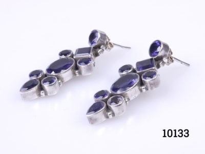 Vintage sterling silver earrings set with iolite stones. Various cuts of iolite stones set in 925 sterling silver. Hallmarked 925 to the back of earrings and butterflies. Each earring measures 36mm in drop length from top stud to base and 15mm at widest point.  Photo of both earrings laid side by side on a flat surface and at a diagonal angle