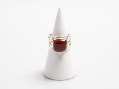 Large sterling silver and carnelian ring. Chunky looking ring with a nice sized square carnelian stone and pierced scrollwork to the shoulders. Very fine thin silver. Hallmarked 925 for sterling silver. Stone measures 12mm square.  Size V / 10.5 Main photo of ring on a cone shaped display stand and ring front facing forward