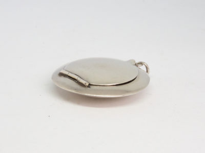 Small circular sterling silver compact. Vintage Art Deco chateleine compact with mirror and puff. Hallmarked for Birmingham assay (date stamp not readable). Measures 45mm in diameter. Photo of compact with opening side up and hinge area to the left of photo