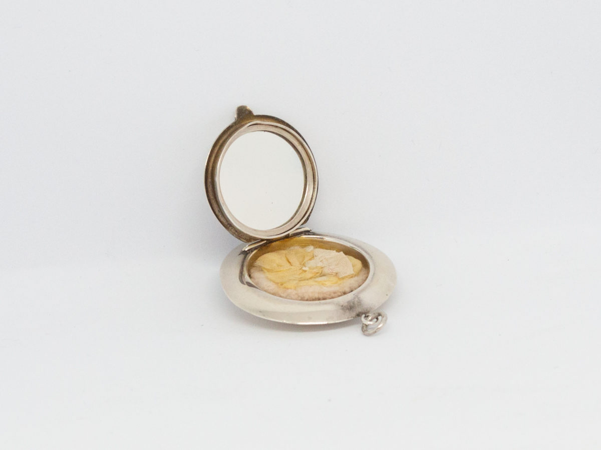 Small circular sterling silver compact. Vintage Art Deco chateleine compact with mirror and puff. Hallmarked for Birmingham assay (date stamp not readable). Measures 45mm in diameter. Photo of compact open showing the mirror and puff