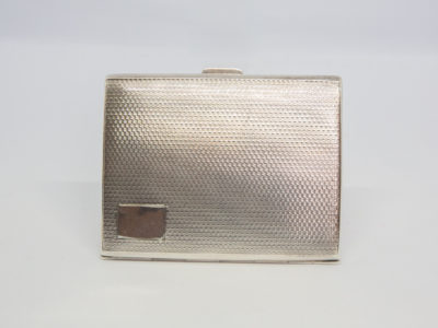 Small sterling silver cigarette case. c1929 Birmingham assayed sterling silver Art Deco cigarette case/business card holder. Lovely engine turned design to both sides with an empty cartouche to the lid for personalisation. Worn gilt interior with elastic intact. Hallmark to both inside covers and a lion passant on the opening lip. Photo of closed case shown upright with empty cartouche in bottom left of picture.