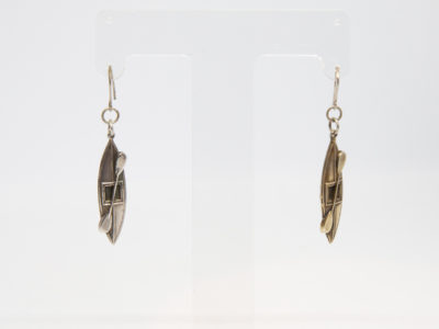 Victorian silver canoe earrings. Very unusual pair of canoe earrings with oar across the top of canoe. One canoe is silver coloured whilst other has slight golden hue and maybe gilded to distinguish 2 sides (Oxford V Cambridge perhaps?) Antique kitemark hallmark to the back of each canoe c1880. (This year being significant in that it is the only time in the history of the boat race that it was postponed for 2 days due to thick fog) Drop length approximately 45mm with canoe measuring approximately 30mm. Earrings weight 2.8gms. Box included. Photo of earrings displayed on a stand.