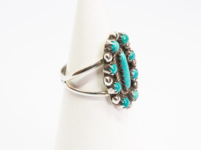 Vintage Navajo silver and turquoise ring. Sterling silver ring set with Bisbee blue turquoise. Stamped sterling with initials BB to the back for Benson Boyd. Wonderful example of fine Native American craftmanship. Ring size M / 6. Ring front measures 22mm by 15mm. Ring weight 4.3gms. Photo of ring displayed on a cone stand and shown from a slight side angle with ring front facing right of photo.