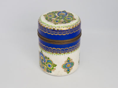 1950s Steinböck Studio lidded pot. Beautiful enamel pot in a creamy off white, hand-painted with a floral design in vibrant greens and blues & all accentuated with 24 karat gold leaf. In excellent condition throughout with no damage to the enamel just wear of the gold leaf around the pot opening as would be expected. Steinböck mark to the base. Measures approximately 64mm in diameter. Photo of pot showing the smaller decoration to the side.