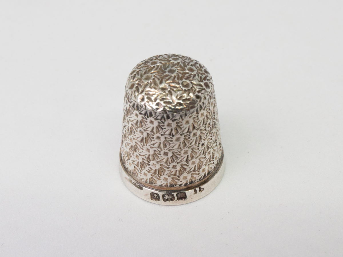 Sterling silver thimble in a fitted velvet case. Lovely sterling silver thimble in a fitted red velvet case with clasp. Fully hallmarked to the side of the thimble for c1927 Birmingham assay. Considerable wear to the velvet case. Thimble measures 20mm long and 16mm in diameter at opening. Thimble weight 2gms. Photo of thimble only shown upright on a flat surface with hallmark just visible at the bottom.