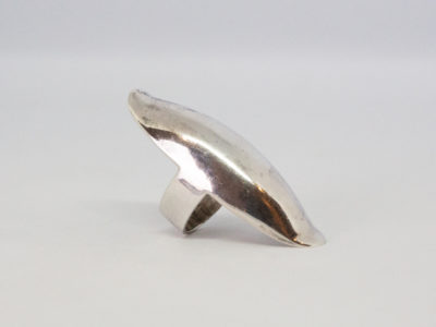 Modern sterling silver statement ring. Amazing solid sterling silver statement ring that covers most of the lower half of the finger. Upward curves at both ends ensure no digging into skin. Full hallmark to the outer band at back for London assay c2001. Ring front measures 55mm long and 20mm at widest. Ring size N / 6.5. Photo of ring on a flat surface and seen from a side on angle showing the length of ring front.