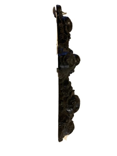 Vintage vulcanite cross carved from one piece of vulcanite. Intricately decorated with roses in a 3d effect. Side view of the cross showing the wider lower end.