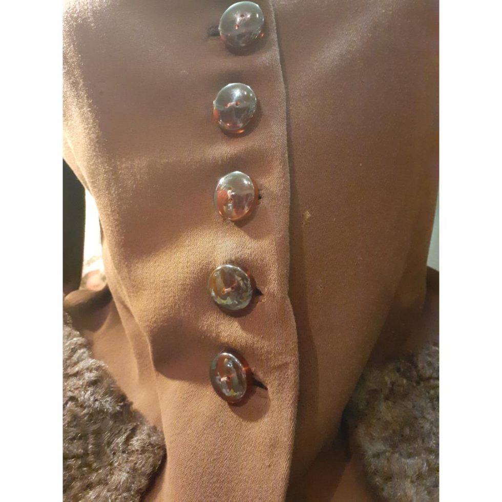 Close up photo of the buttons area showing the small hole right of the third button.