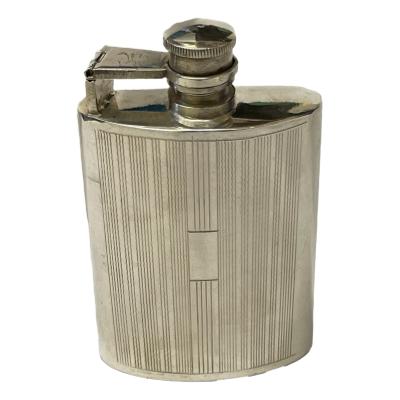 A vintage solid silver hip flask with a hinge bayonet twist cap and engine turned decoration . It is stamped sterling silver to base and weighs 120 grams. There is some slight scratches to top of bayonet arm. There is a vacant panel for a small inscription. Main photo of flask seen from the front and showing the vacant panel.