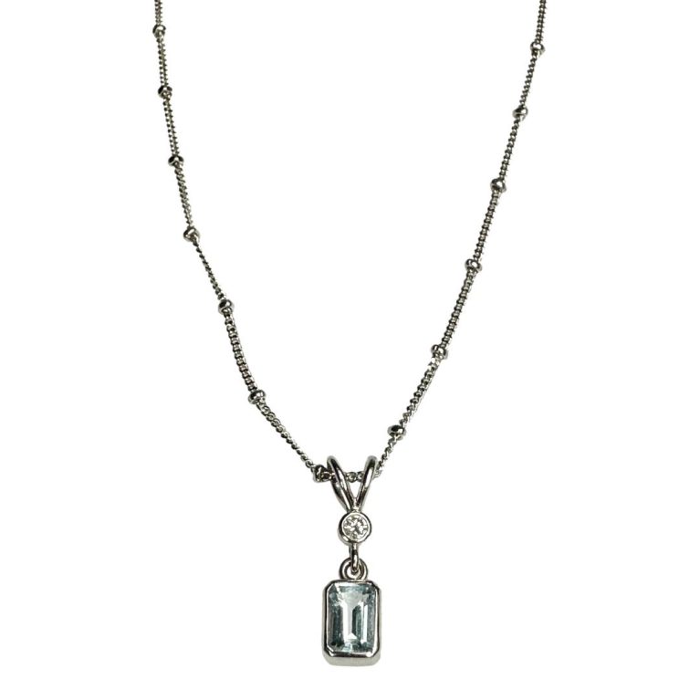 Main photo of necklace and pendant seen from the front and excluding the clasp area. The aquamarine is a beautiful pale blue and is hanging from a bail which houses the diamond to its centre.