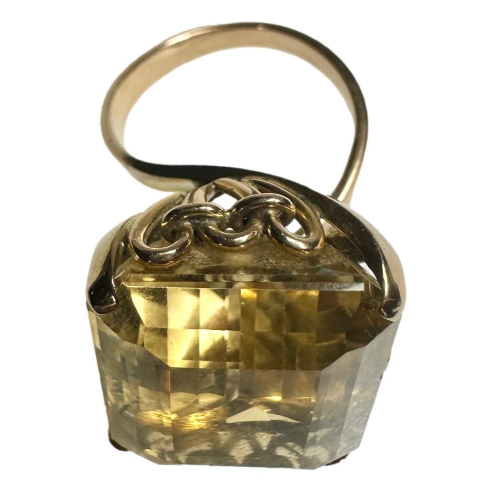 Photo of ring taken from a raised angle with the citrine taking up most of the photo in the foreground . At the back, the unusual looped gold band can be seen - a little like a helter-skelter slide!