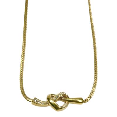 A vintage Attwood & Sawyer love heart knot necklace. One half of knot is embedded with cubic zirconia stones. Main photo showing the main lower area of necklace with heart know to the centre.