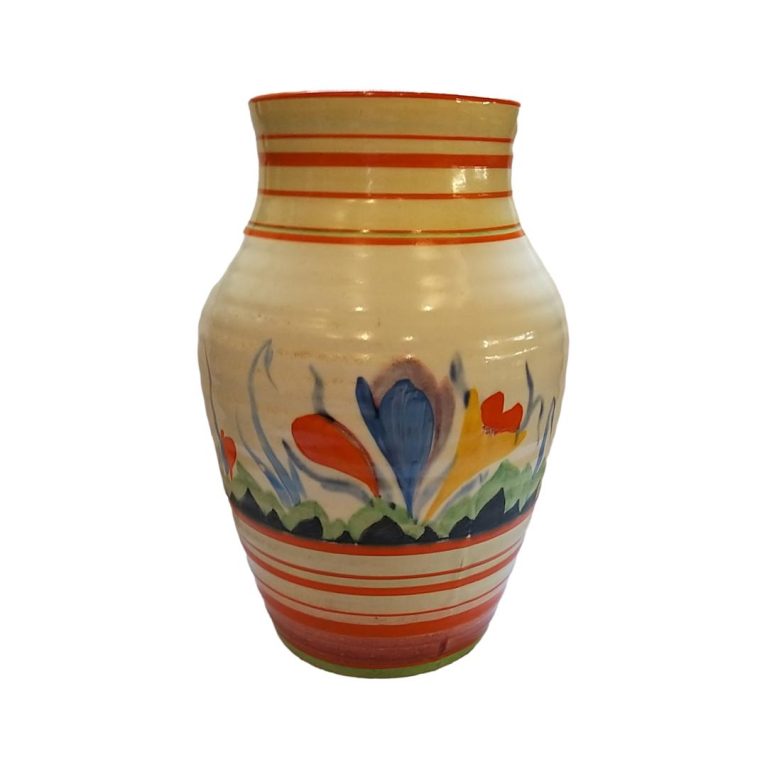 Main photo of vase shown from an eye level angle with large blue crocus side showing. Other than the single blue crocus the other colours are trademark yellows and oranges.