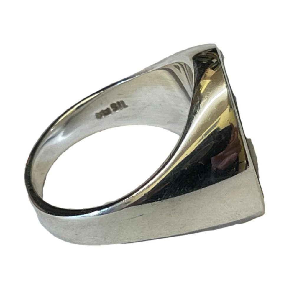 Photo of ring with ring front facing right. The SIL hallmark is visible to the inside band.