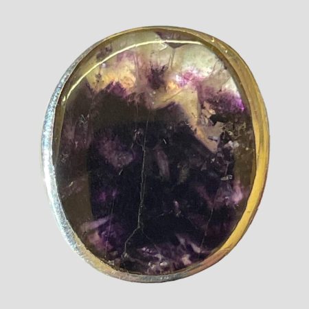 Main photo of ring looking straight on from the front at the Blue John stone. The darker purple of the stone covers most of the ring with a little lilac and white patch at the top.