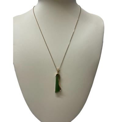 Vintage 9 karat gold abstract pendant set with a slim length of apple green jade. Hallmarked to the pendant bail and clasp. Pendant drop length 40mm from top of bail and 10mm at widest. Main photo of necklace displayed on a stand.