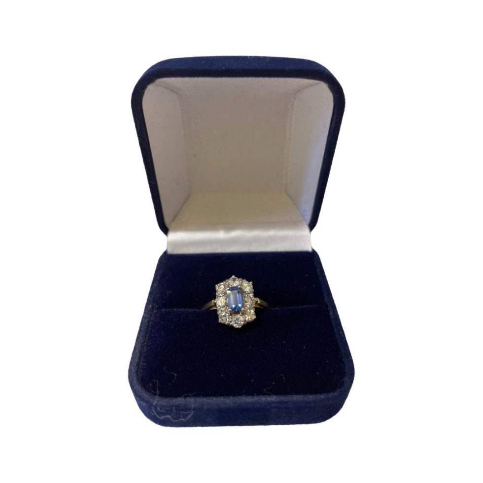 Photo of ring displayed inside a blue velvety box.