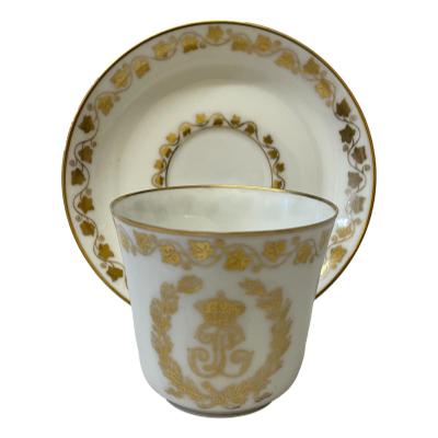Antique Sêvres cup and saucer in white with monogrammed LP between a garland of vine leaves and a frieze of ivy leaves. Dated to c1846 in the reign of King Louis Philippe. Saucer measures 85mm in diameter at base & 125mm at top. Cup measures 35mm in diameter at base, 68mm in diameter at top, 85mm at widest to handle and 62mm tall. Main photo with cup placed in front of the saucer which is displayed upright on a stand. The decorated side of cup (opposite end to handle) is shown.