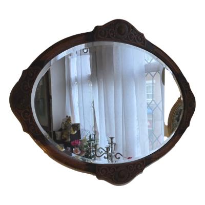 Fabulous Arts and Crafts mirror in solid oak. Oval bevelled mirror with cut out scroll decoration. Measures 840mm length 630mm wide 20mm deep. Main photo showing whole mirror.