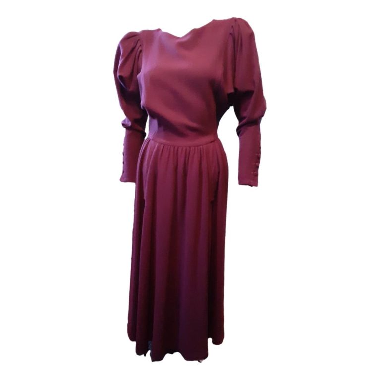Main photo of full length of dress seen from the front. Stunning colour like a fine claret. Fitted waist, puffed upper arms and fitted below the elbow with buttons detail. Very classy and sassy little number!
