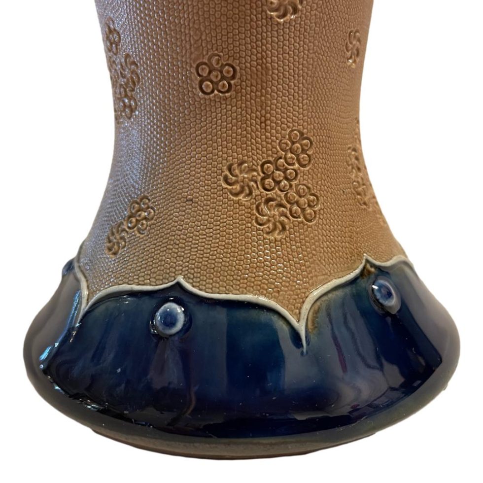 Close up photo of the lower area of vase around the base which is glazed in Dolton blue. Small floral indentations are included in the terracotta central area.