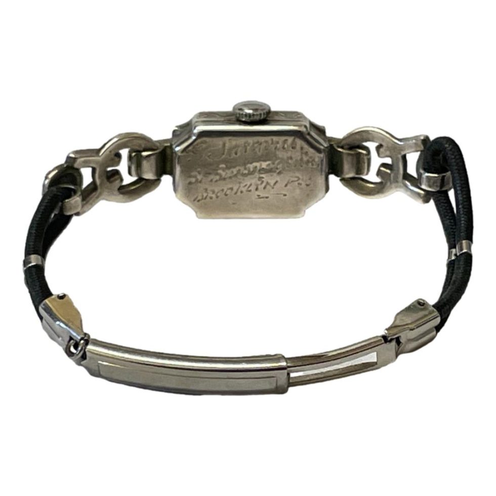 Photo of watch laid on a flat surface and seen with clasp closed and in the foreground