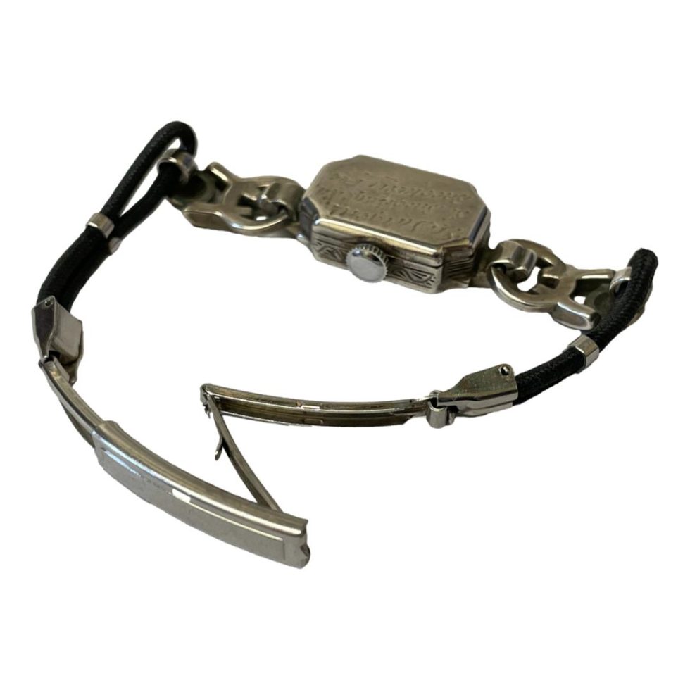 Watch shown with clasp area in foreground and shown open. Clasp is deployant type.