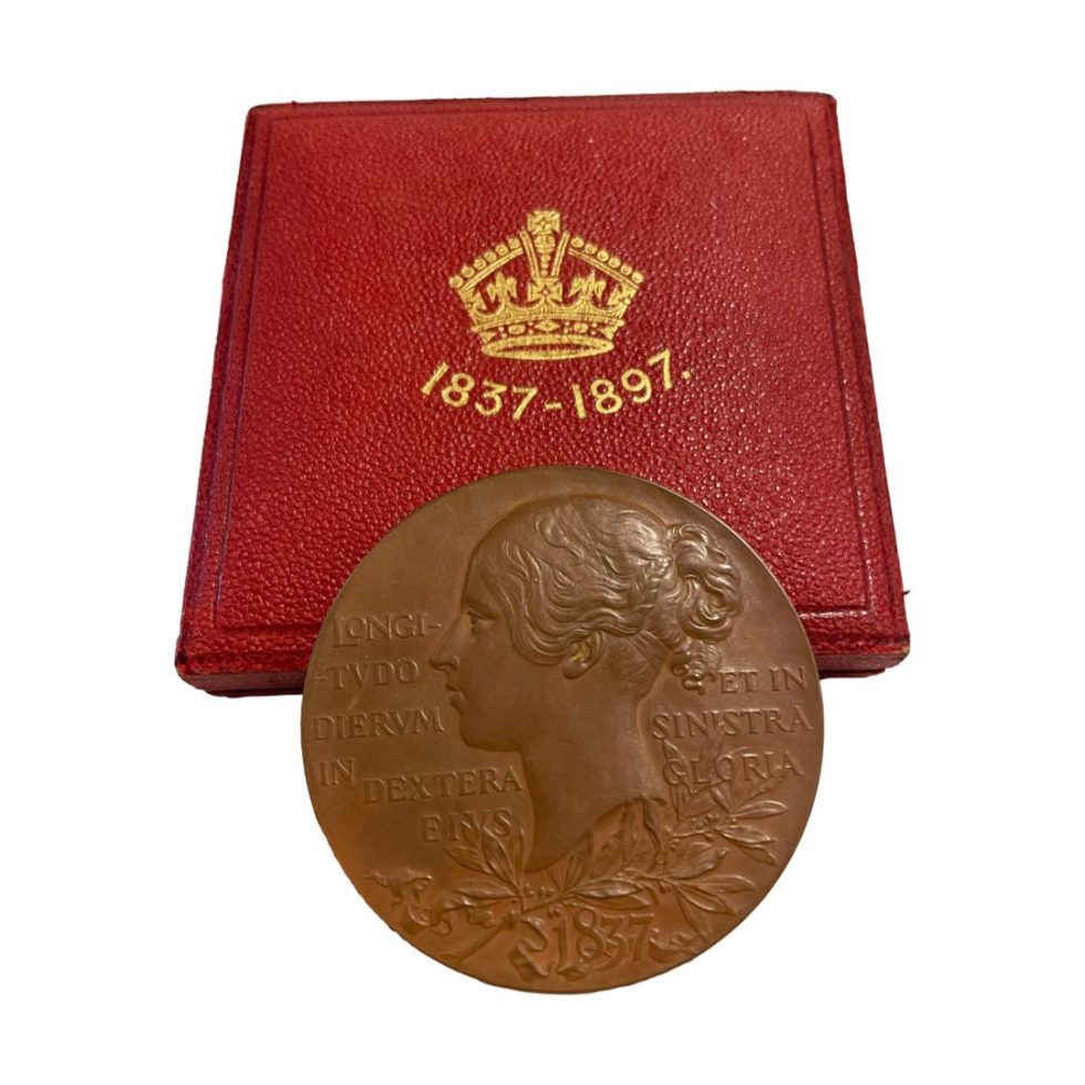 Main photo of medal shown leaning up against its case with the young Queen Victoria side on display.