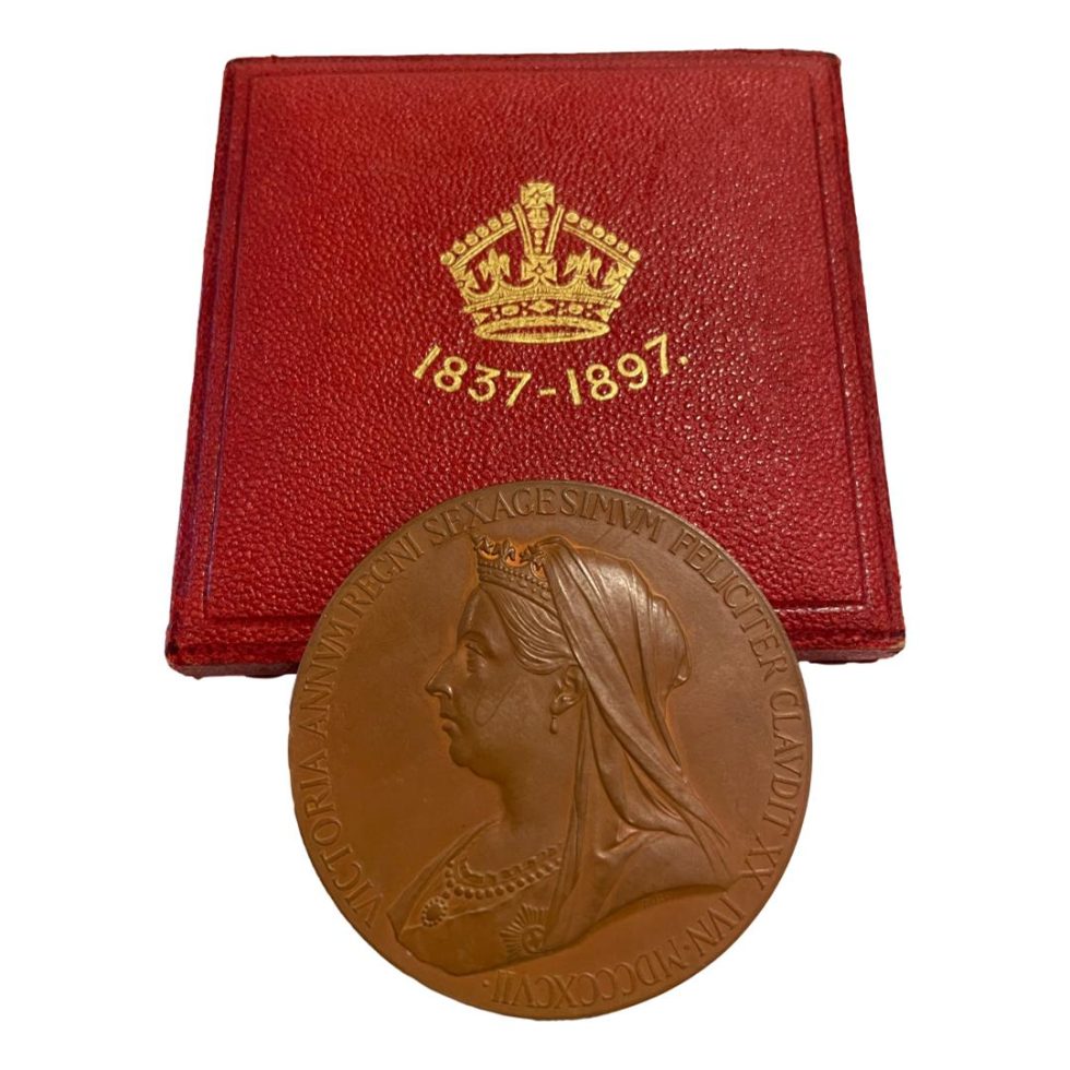 Photo of medal displayed leaning against the closed fitted case and showing the later Queen Victoria side of medal.