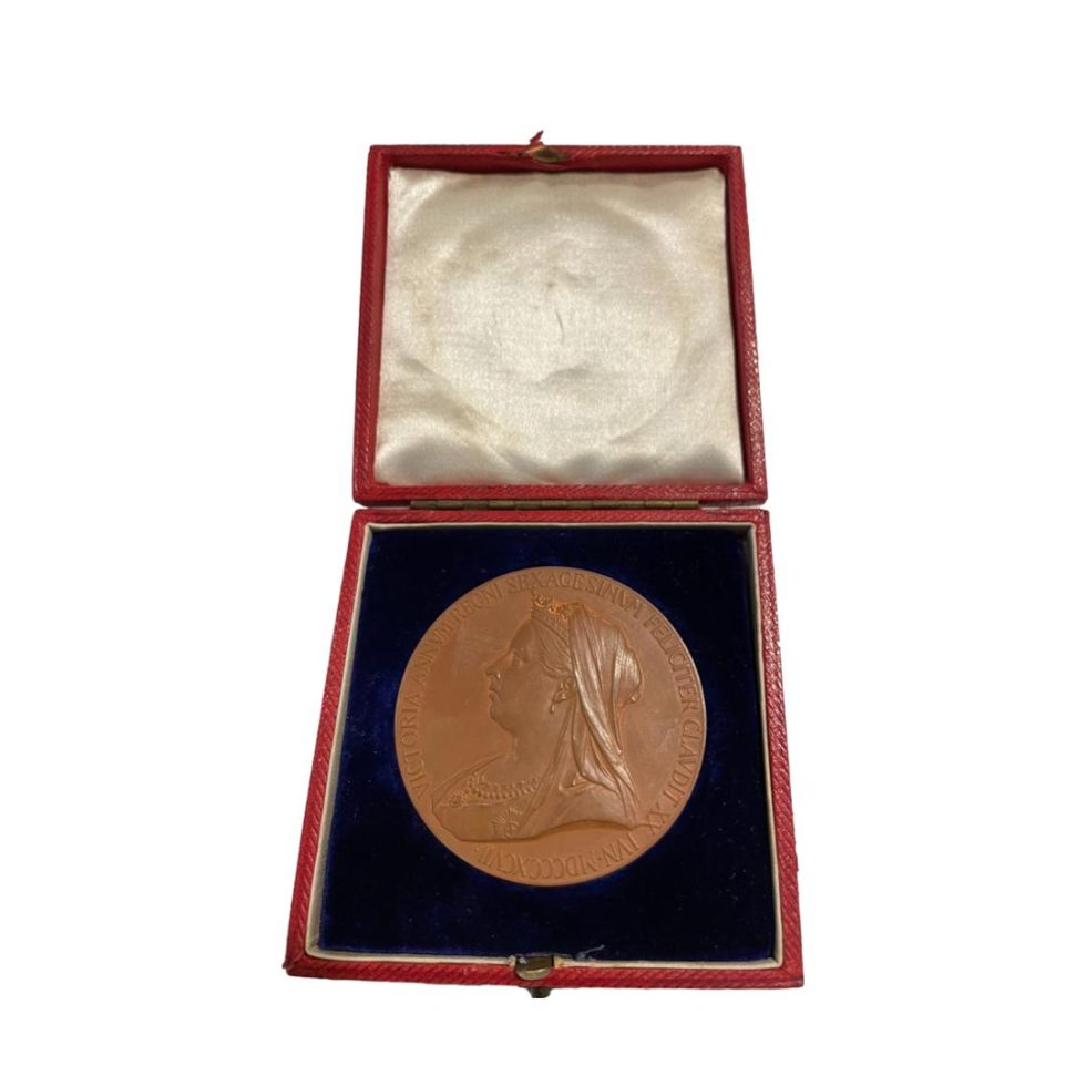 Photo of medal inside its fitted case with the older Queens image on display.