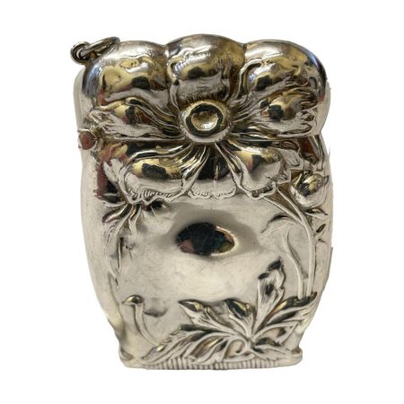 Main photo of vesta seen from one side angle showing the Art Nouveau floral design. The photo is taken at an angle looking downward.