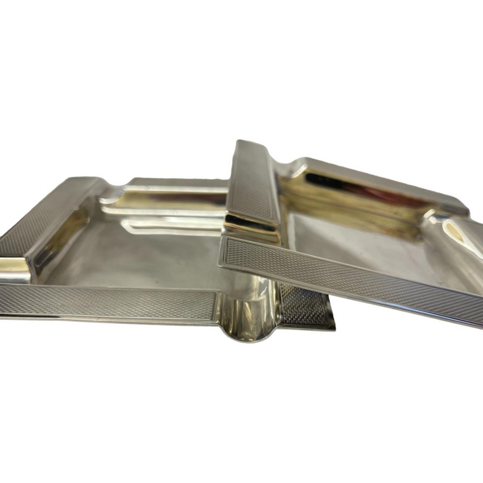 Photo of both ashtrays one laid flat with other raised onto the right side.