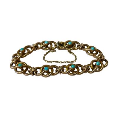 Antique gold bracelet with turquoise. Substantial bracelet in 9 karat yellow gold with turquoise stones from early 20th century. Solid clasp fastening with safety chain. Inner bracelet measures 65mm when closed and 95mm when open. Main photo showing bracelet laid on a flat surface in a circle with clasp closed and safety chain to the centre of bracelet also in a circle.