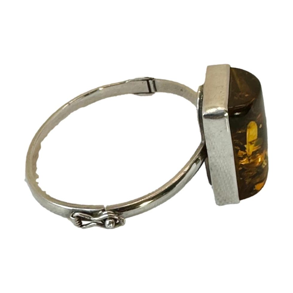 Photo of bracelet seen from side angle with the amber on the right and clasp area in foreground.