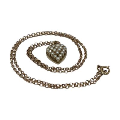 9 karat seed pearl heart pendant and chain. Pretty yellow gold heart pendant set with seed pearls on a 9 karat rose gold chain. Hallmark to the chain clasp only no hallmark to the pendant. Small hole to one side of pendant. Heart pendant drop length 20mm. Main photo of necklace laid on a flat surface with the heart pendant to the centre and chain laid out in a swirl pattern around the pendant.