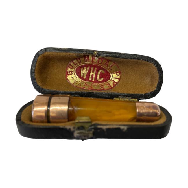 9 karat gold and amber cheroot holder. Small amber cheroot holder in original case with 9 karat rose gold bands. The 2 gold bands at outer extremes are fully hallmarked for Birmingham assay c1911. The second inner band is hallmarked for a later date and has probably been replaced. Comes complete with original fitted case. Cheroot holder measures 48mm long. Main photo of cheroot holder displayed inside its case with WHC Gold Medal Pipes stamp visible on the inside of the lid in red and gold.