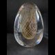 Main photo of vintage Murano egg paperweight displayed against a dark grey background. On the inside of the egg is a golden egg shape in net form so an egg shape made up of golden criss-crossed strands. The exterior of the egg is clear glass. A beautifully and expertly crafted piece.