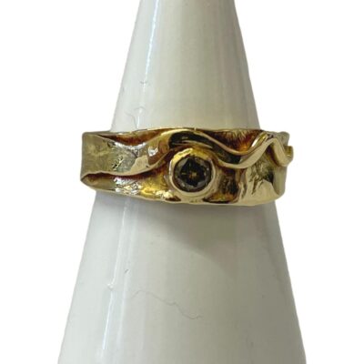 18 karat gold ring set with a small diamond. A nice solid and modernistic 18 karat gold ring set with a small round cut diamond. Full hallmark to inside band. Ring size M / 6. Measures 7mm wide at the ring front. Main photo of ring displayed on a cone and shown forward facing.