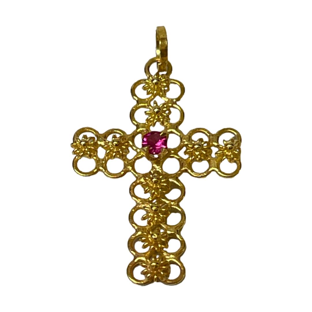 18 karat gold cross with ruby. Very pretty petite 18 karat gold cross with a round cut ruby to the centre. Lovely detail to the gold cross which is made up entirely of tiny circles and decorated down the middle of each arm with gold flowers. Hallmarked 18kt to the bail. Drop length from bail 30mm. Main photo of cross seen forward facing. The 2 rows of small circles that make the base of the design can be seen through the lines of flowers on each arm with the single ruby at the centre of the cross.