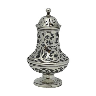 Small shaker in sterling silver with crystal lining. Small and sweet sterling silver shaker in an elaborate cut out design which allows the crystal to be visible (and any contents therein). Full hallmark to lower rim of the lid, around the top of the shaker base and on the bottom. c1838 London Reily & Storer. Some discolouration of the silver at base. Measures 42mm in diameter at base, approximately 55mm at widest and 28mm across the top. Lid is 36mm in diameter. Main photo of shaker seen from a near eye level angle with lid in place. The main body is conference pear shaped with a single footed stand. The lid is in place which has a ball finial.