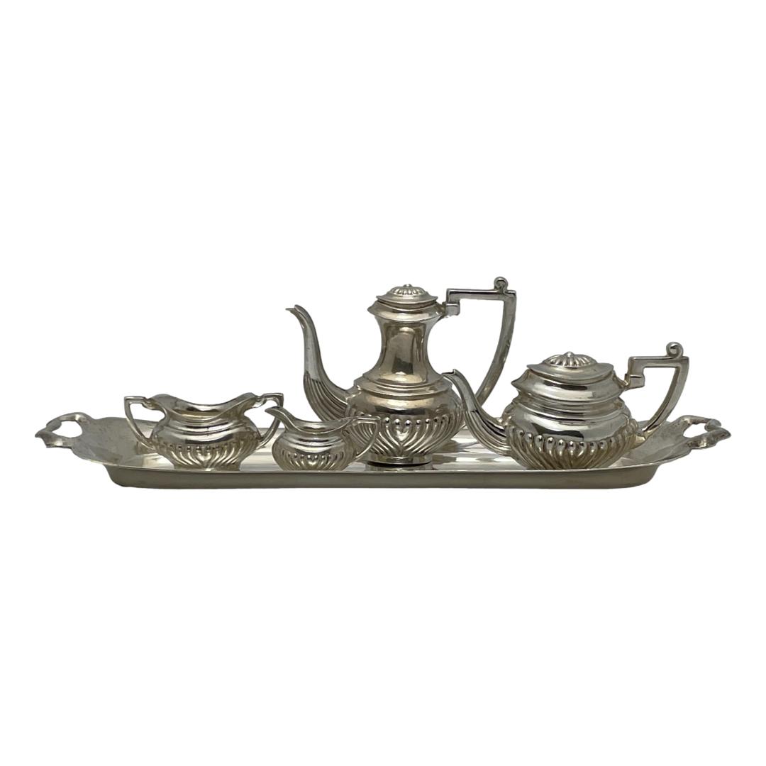 Vintage miniature sterling silver tea/coffee set. Wonderfully detailed miniature 5 piece sterling silver set comprising of a tea and coffee pot, sugar bowl, creamer and tray. Incredible detail in a Georgian style, each piece is fully hallmarked for Birmingham assay c1971 except the sugar bowl which is unmarked. The lids of the tea & coffee pots can be removed and both lids have a lion passant & date stamp. Measurement of coffee pot 54mm by 22mm widest and 42mm tall. The jug 27mm long, 12mm widest and 15mm tall. The tray is 148mm long and 40mm wide. Main photo of the set displayed with the tea and coffee pots, sugar and creamer on top of the tray. The pots are displayed on the right of tray and the sugar and creamer on the left