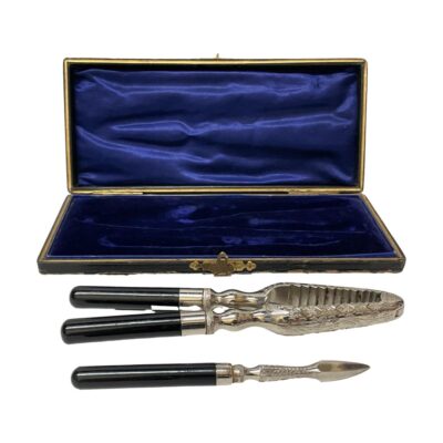 Vintage nut or lobster cracker set. Very handsome Art Deco cased cracker set for nuts or lobster with Bakelite handles and chrome tool ends which are engraved in a foliage design. Presented in original blue velvet and silk lined case. Both tools are in excellent order with only minor wear to the outside of case. The cracker measures 157mm long and 30mm wide when closed, 62mm wide fully open. The pick measures 123mm long. Photo of the cracker and pick removed and placed in front of the open case, The handles for both tools are on the left with the chrome ends on the right.