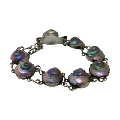 Main photo of bracelet displayed in a circle on a flat surface with clasp closed The bracelet is formed with the shells on silver discs which are linked together with 2 chains per shell. The clasp also houses a shell so when worn, the bracelet is uniform all round with the clasp shell only slightly raised above others.