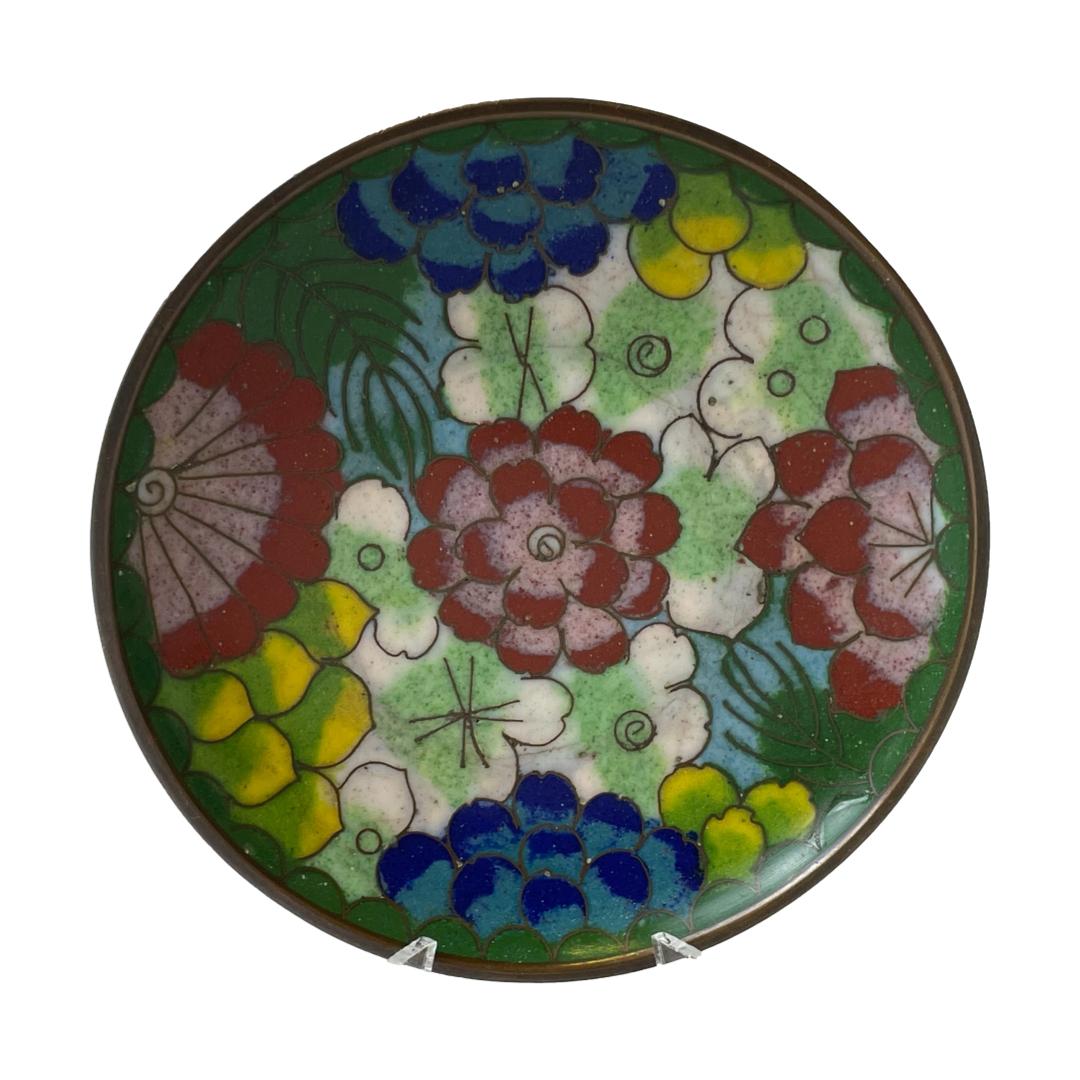 Main photo of antique Chinese cloissoné dish displayed on a small plate stand with the centre of dish on display. Beautiful multi coloured floral design with 3 larger red flowers going across horizontally (in this photo) the smallest in the centre and half of the larger blue flowers above and below. In the background, the smaller flowers are white, green, pale blue and yellow which creates a nice contrast with the larger bolder coloured flowers.