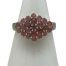 Main photo of silver &ruby cluster ring displayed on a white cone shaped stand and seen with the ring front forward facing. This is quite an unusual ring in that the cluster is side wide rather than circular. The rubies are a sweet pale pink and red colour mix which marries well with the silver.