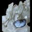 Main photo of boulder opal &diamond necklace displayed on top of a rock of natural quartz crystal. The pendant is to the lower right with the front on view. This is a lovely natural opal stone set in pendant form with a diamond in the bail. The gold chain has been draped over the crystal.